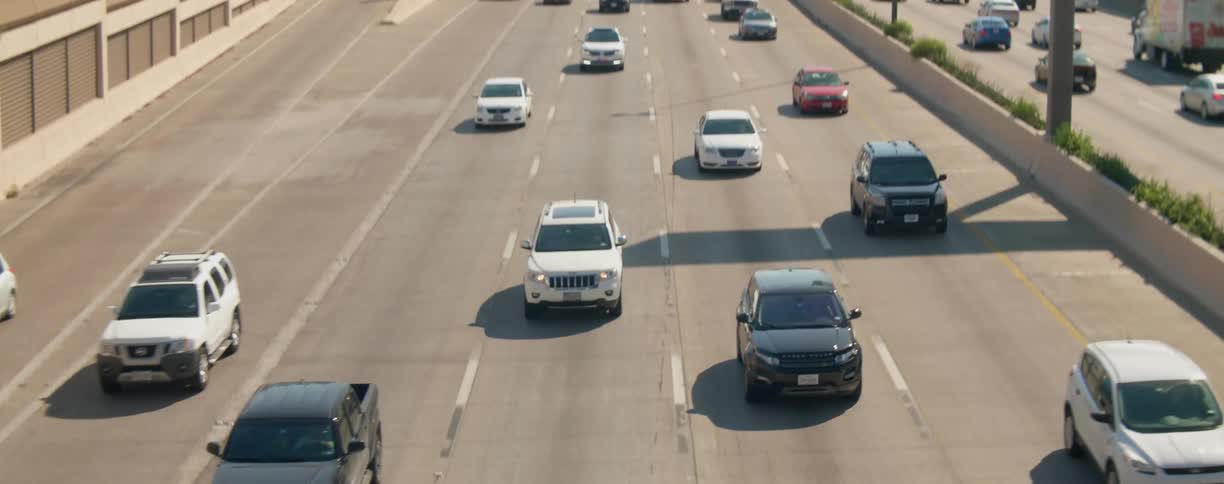 A highway with vehicles with the city skyline in the background