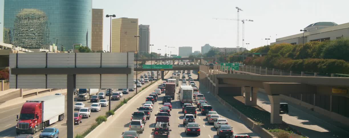 A traffic jam starts to form on a freeway heading into a city