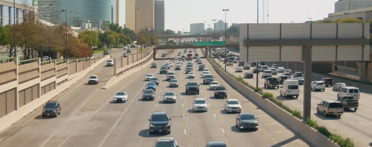 Vehicles drive on busy divided highway in the city