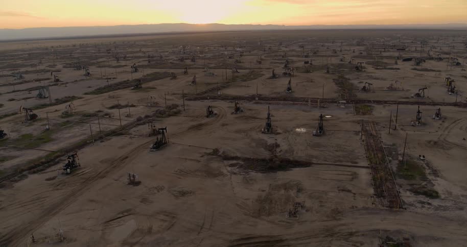 Aerial view of oil pumps on an oil field at sunset