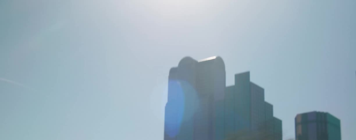 Traveling past city buildings on a bright sunny glaring day