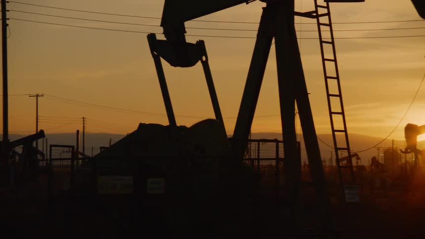 The oil rig is working at sunset