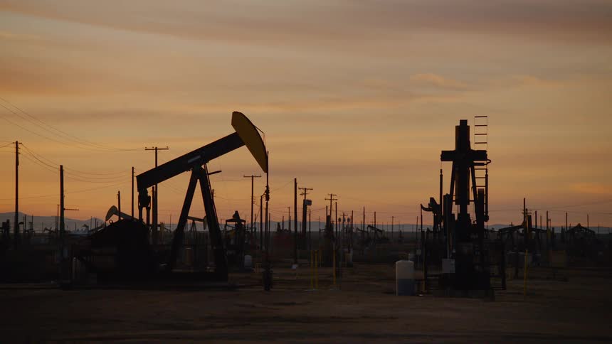 Several oil rigs pump for oil outdoors