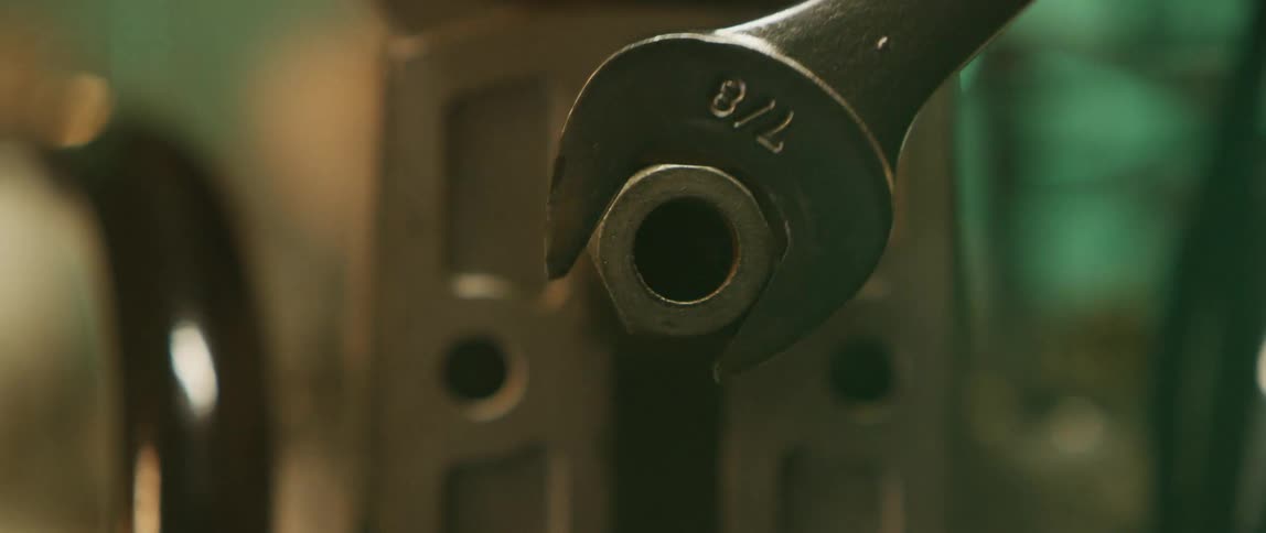 A wrench turns a screw counterclockwise