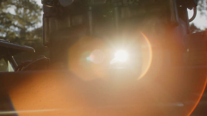 Evening sunlight through the pieces of an engine outdoors