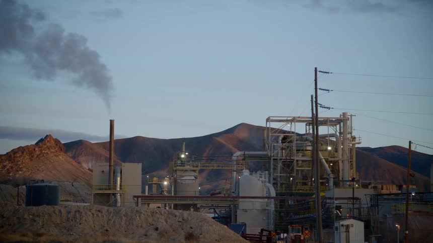 A factory near the mountains at sunset