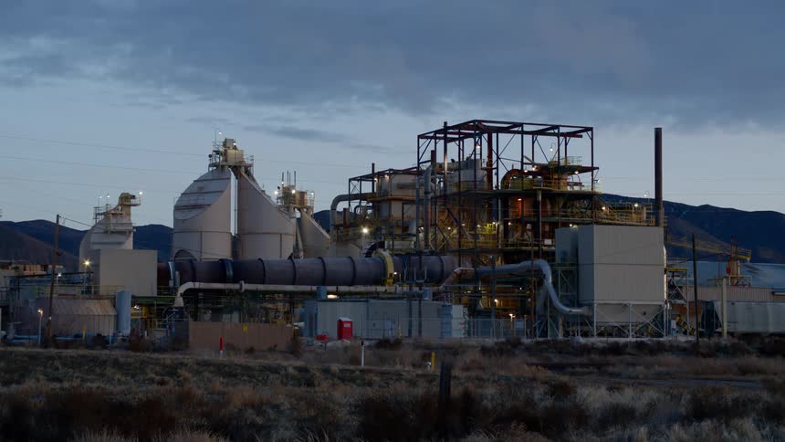 A refinery in a field under a dim sky