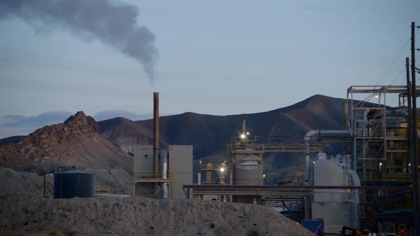 Smoke rises from a factory in the desert