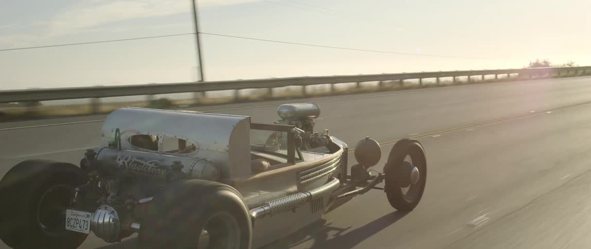 Roadster cruising on the highway at sunset
