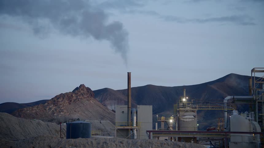 Chimney on a factory spews smoke on the air
