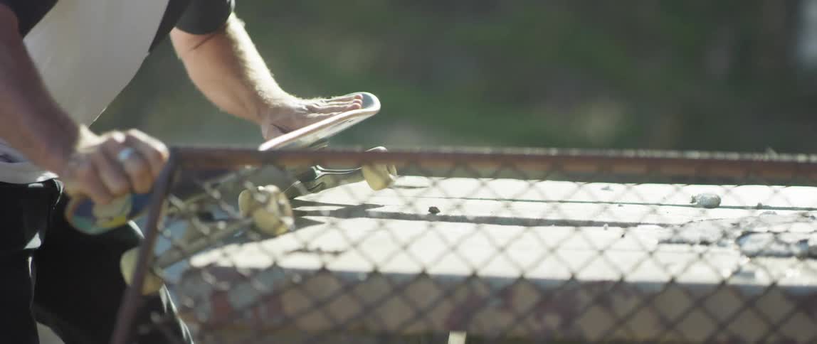 A man runs his skateboard over a wooden slab