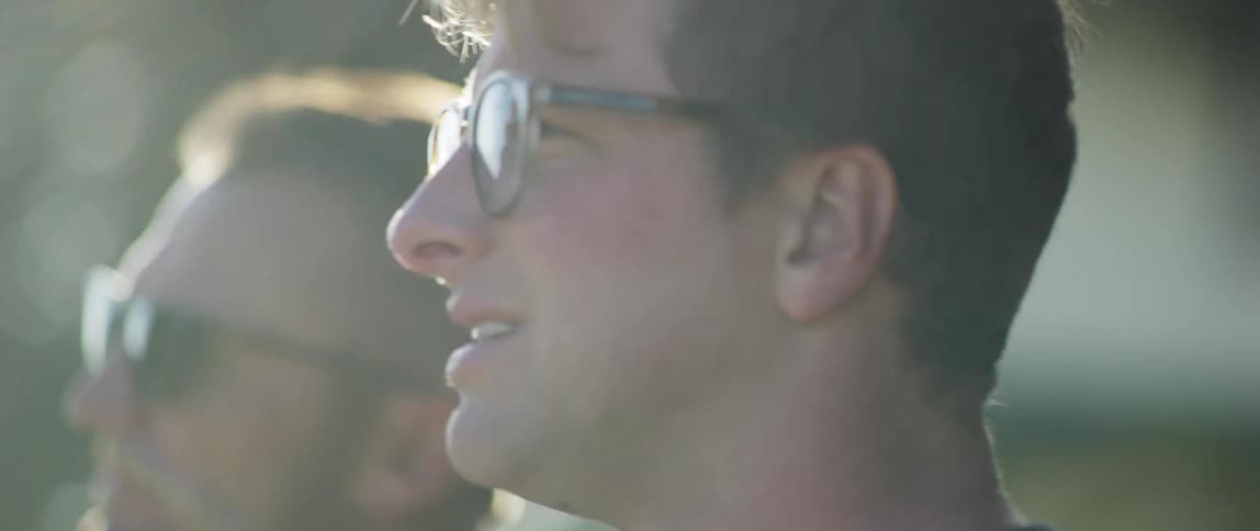A man with sunglasses talks and expresses thoughts feelings and ideas to a man wearing glasses