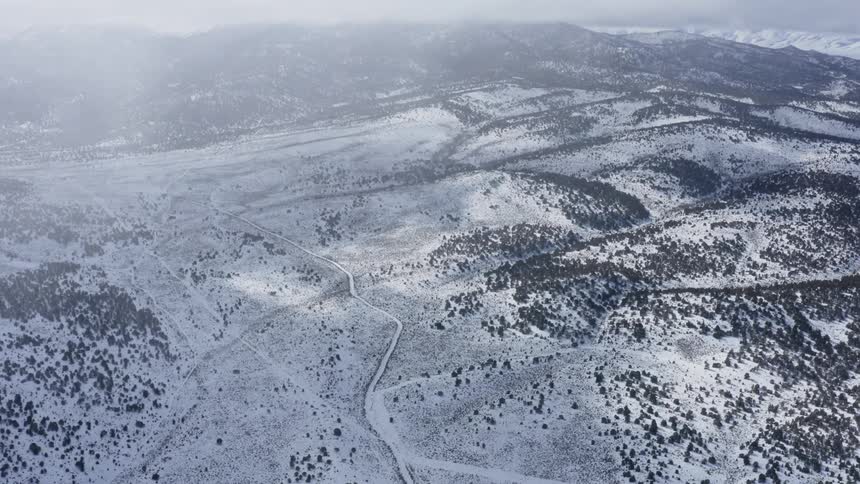 Snow covered roads lead to a mountain range