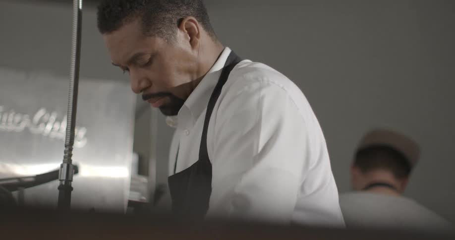 A man is washing dishes in a restaurant