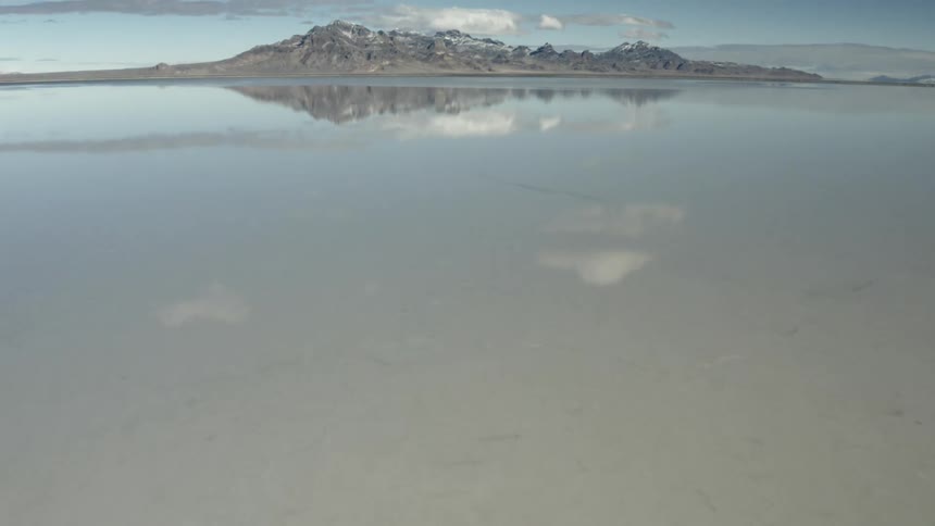 A lake with mountains and the sky in the background