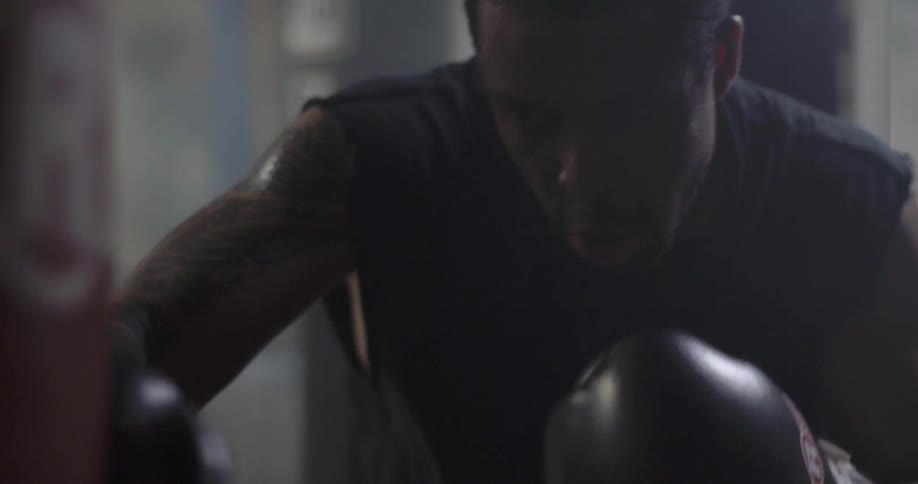 A boxer is punching a bag in a gym