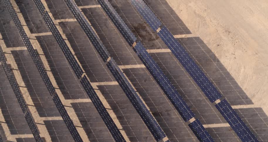 Rows of solar panels lined up in a desert