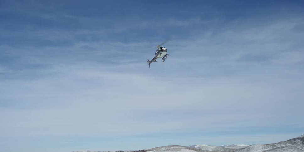 A helicopter is flying above the ground