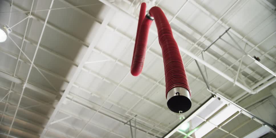 A red hose hangs down from a ceiling