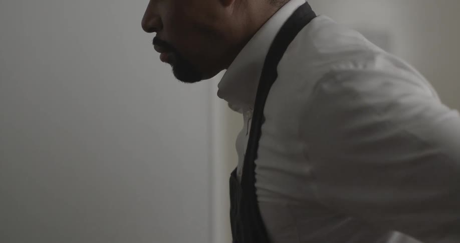 A man putting an apron on