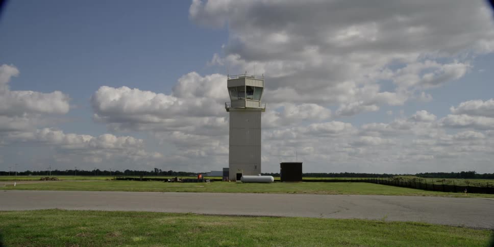 A control tower sits above the tarmac at a small airport