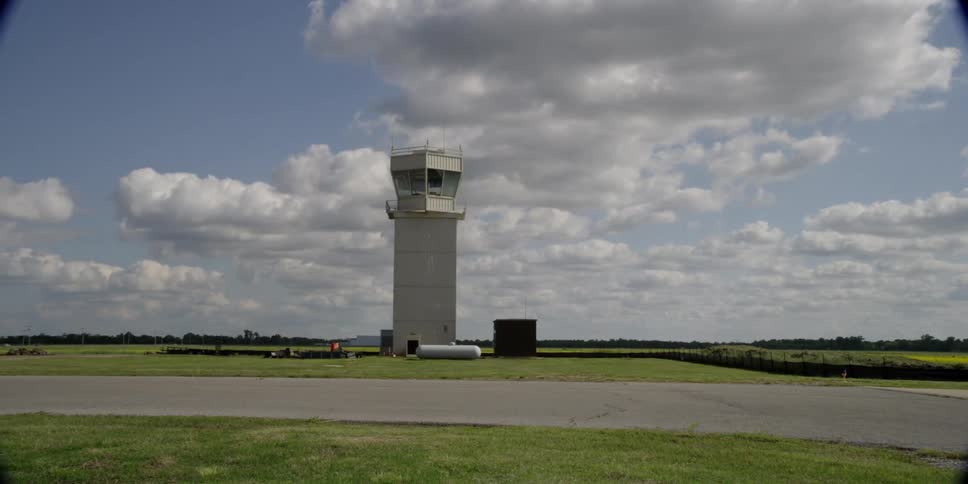 A flight center overlooks an air strip in a wide field