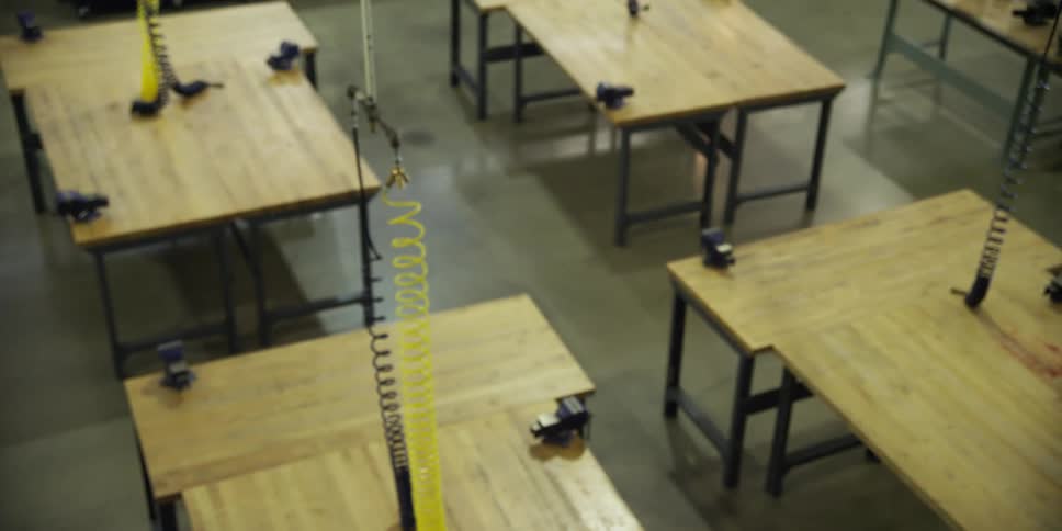 The shop is filled with tables and wires hanging down