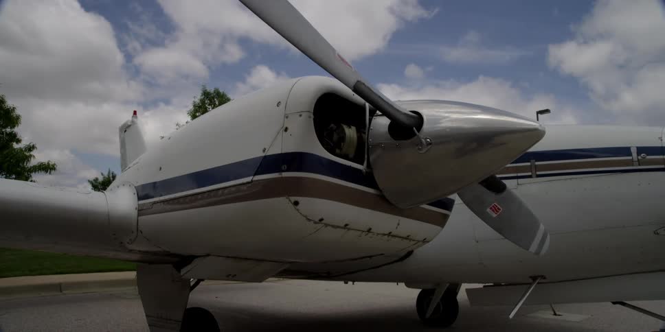 An airplane on the tarmac with trees and the sky in the background