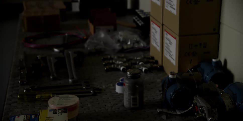 Various tools boxes and wires sit on a table in a workshop
