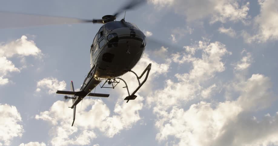 Helicopter stay in one place in the air with clouds in the background
