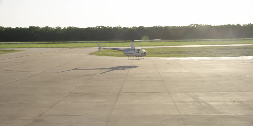 Helicopter hovering near the ground in an airfield at day