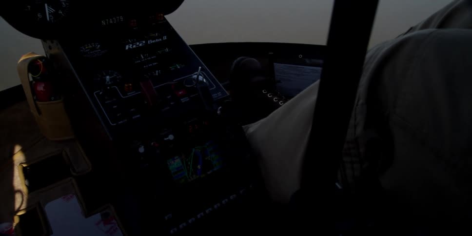 A pilot guides a helicopter through fog