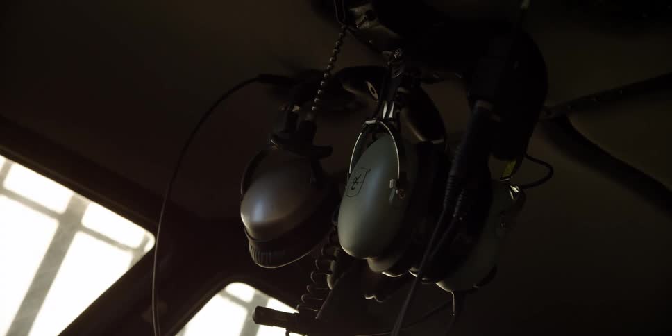 A headset hangs from the ceiling of a aircraft