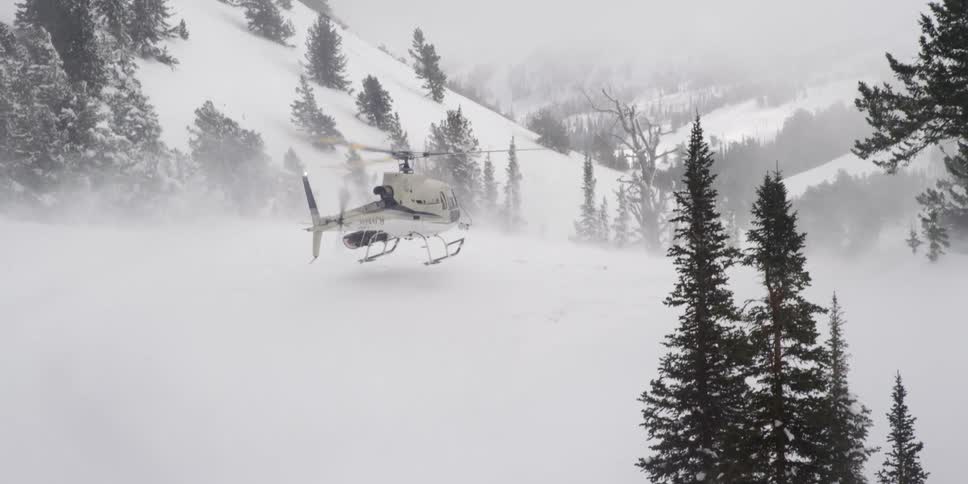 A helicopter landing in the snow during a storm