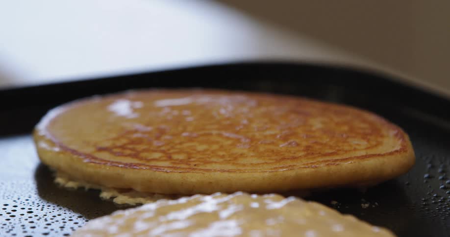 A white person flips a pancake during cooking