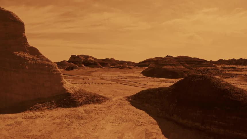 Mounds and mountains rise up from a desert terrain