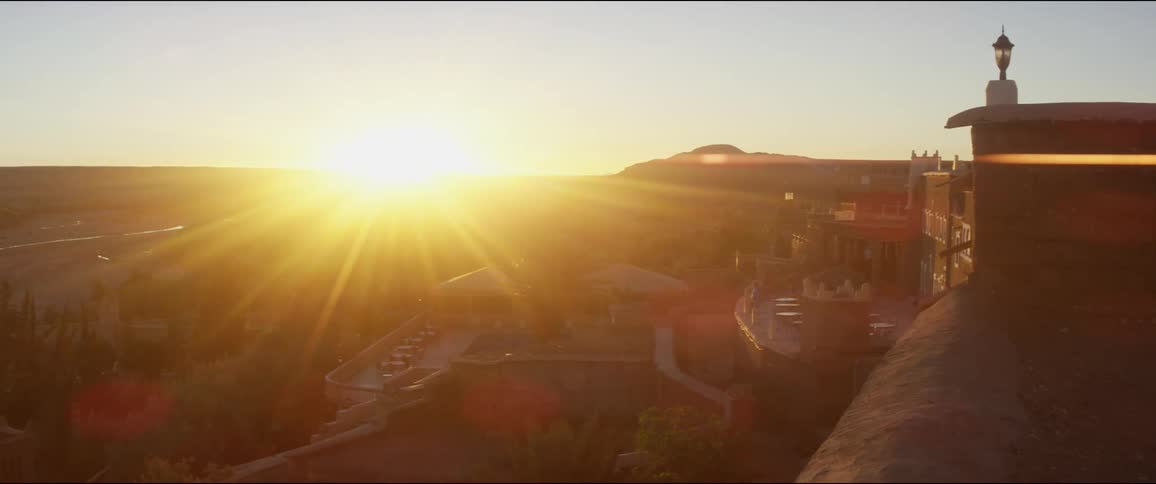 The sun sets over a shopping plaza