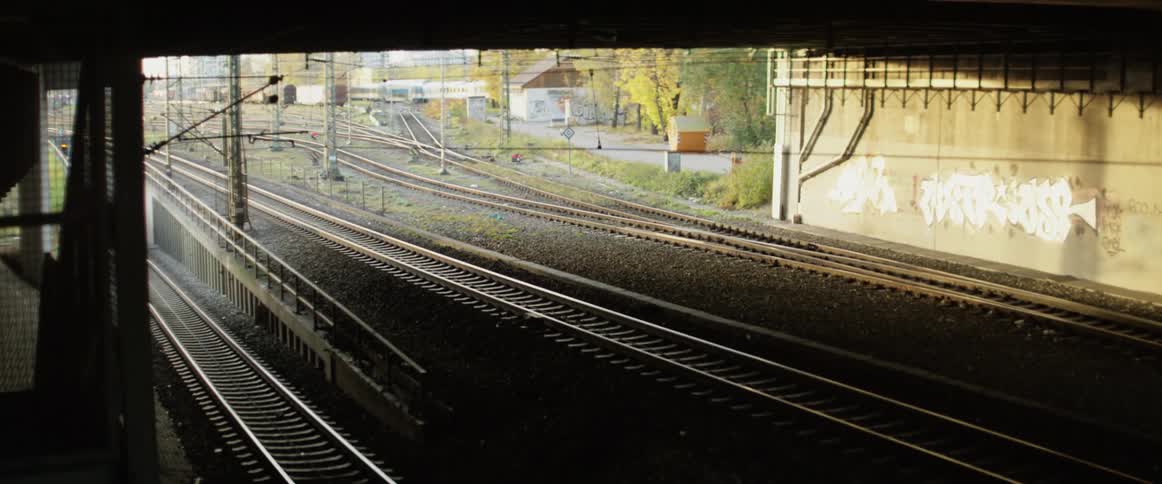 Various railroad tracks run into a dark tunnel