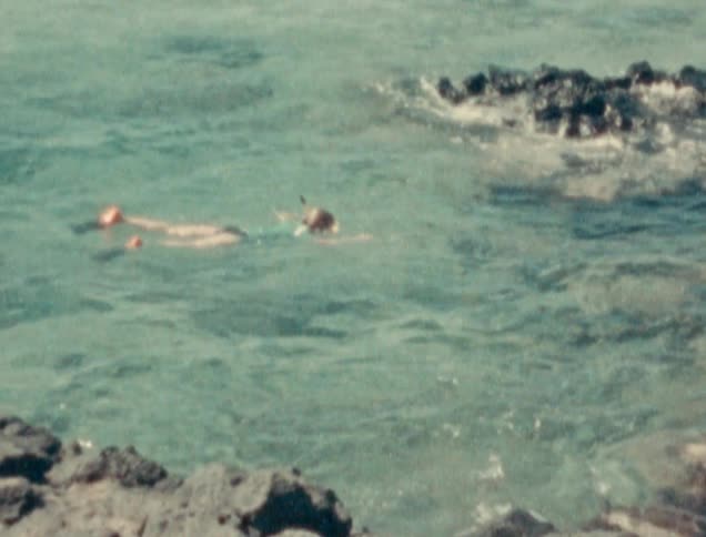 A girl is swimming in the ocean