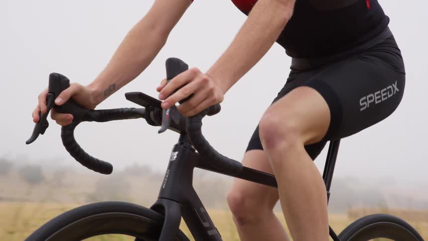 A man rides his bicycle past a field