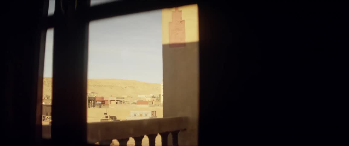 Buildings sit in the desert under a blue sky