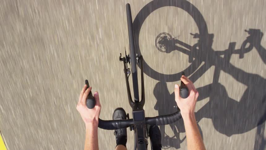 Cyclist pedals a bicycle as it rides on the road