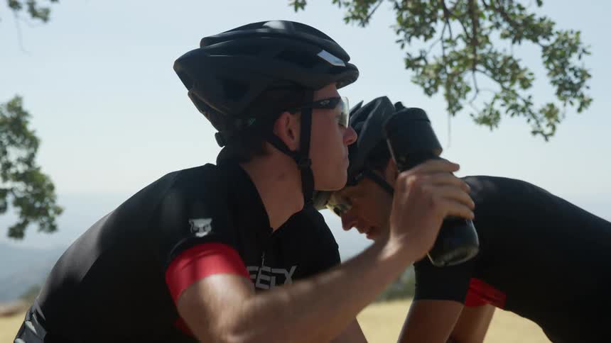 Two men are riding bicycles outdoors