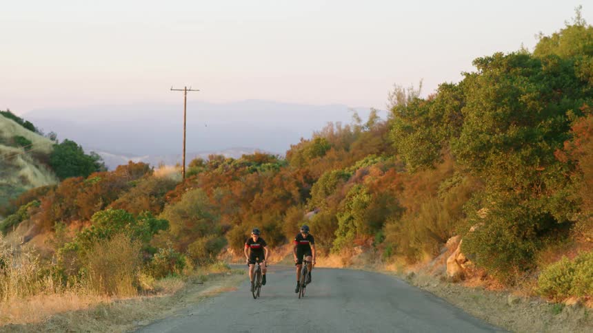 Cyclist riding uphill on a mountain road on a hazy day
