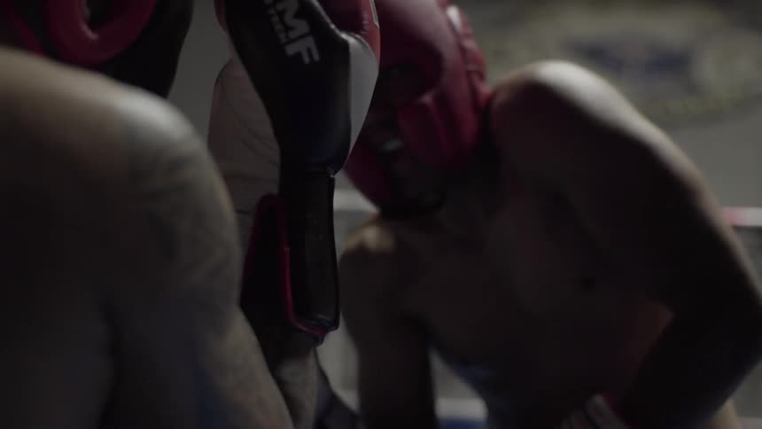 Two men sparing in a boxing ring