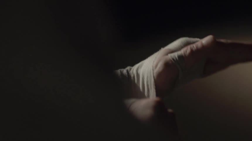 A person wraps their wrists and hands with athletic tape