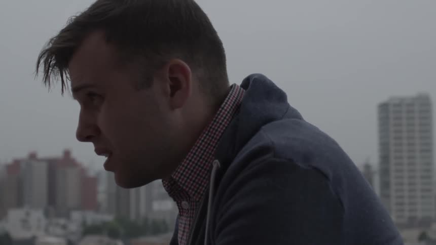 A man looks over a city on a cloudy day