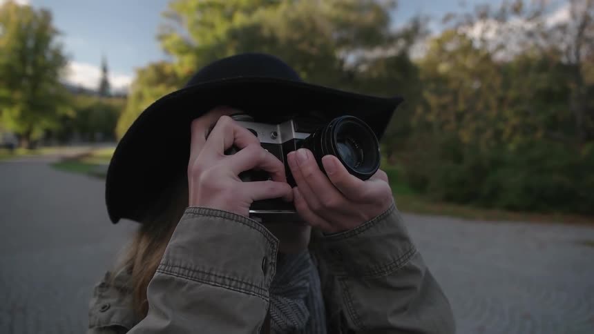 A woman takes a picture in a city