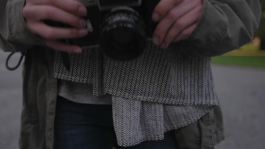 A person slowly lifts a camera out of view
