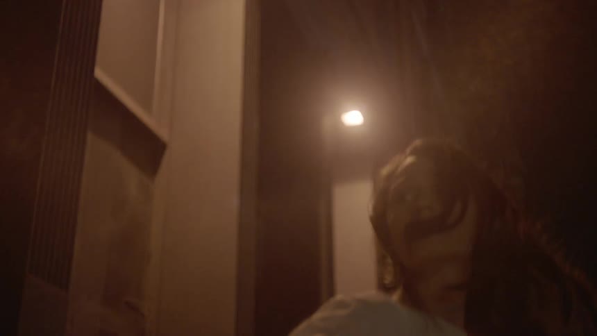 A woman looks back worried at night